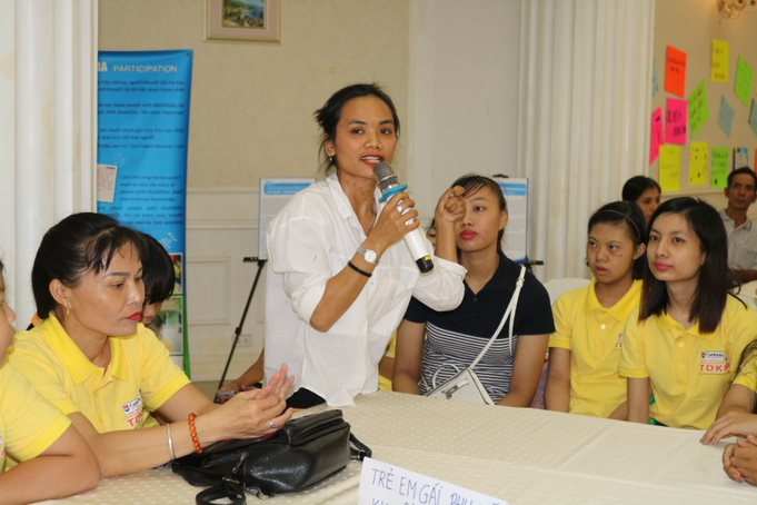 There is a young woman wearing a white shirt and holding a microphone