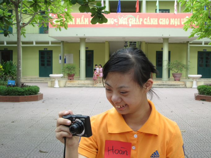 There is a girl taking a photo for a photo-voice project.