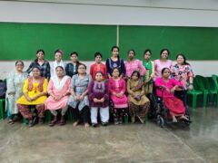 A group of women and girls with disabilities wearing colourful traditional clothing.