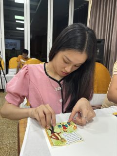 A woman is sticking an image onto her product.