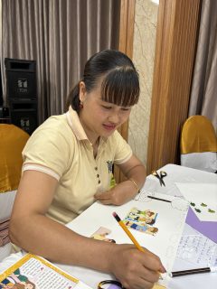 A woman is writing with a pencil.