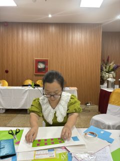 A woman is decorating her artwork.