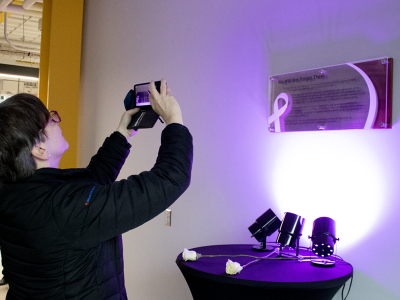 Person taking a photo of white ribbon day honourary plaquethe