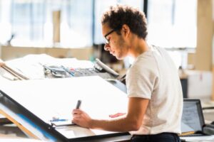 student at drafting board in class setting