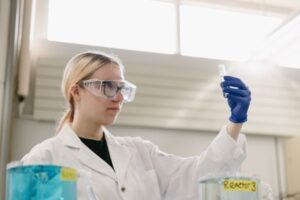 student in lab setting holding test tube