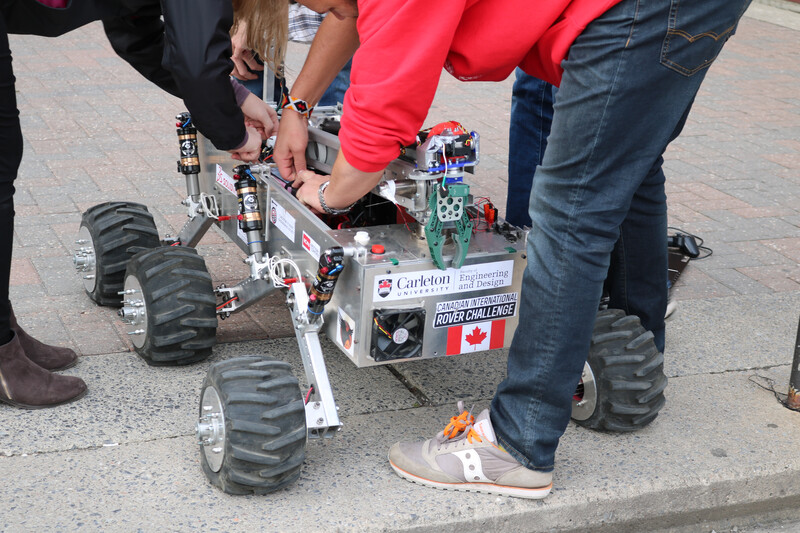 Students work on robot with six wheels