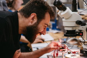 Student with microscope and electrical devices 