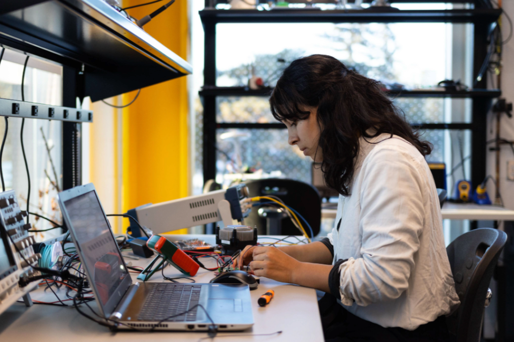 Woman sits at desk with laptop and