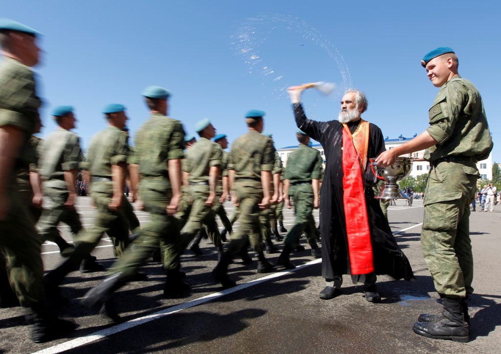 Russian Orthodox Clergy member blesses soldier marching