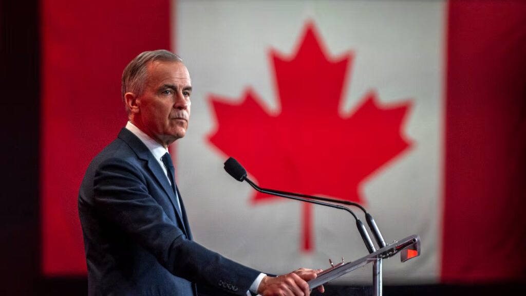 Pm Mark Carney infront of a Canadian flag