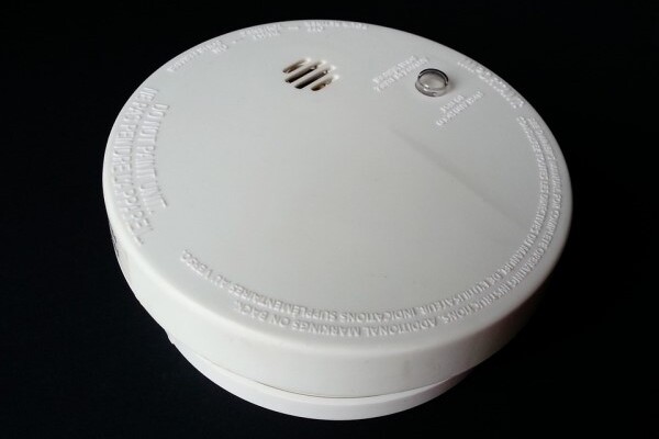 Smoke alarm sitting on black background.