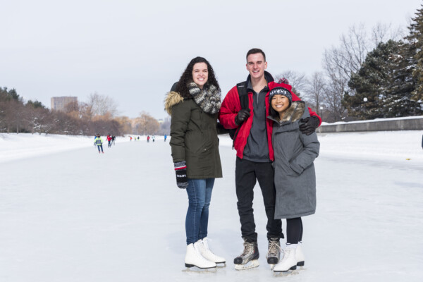 Students on the canal, wearing skates, smiling
