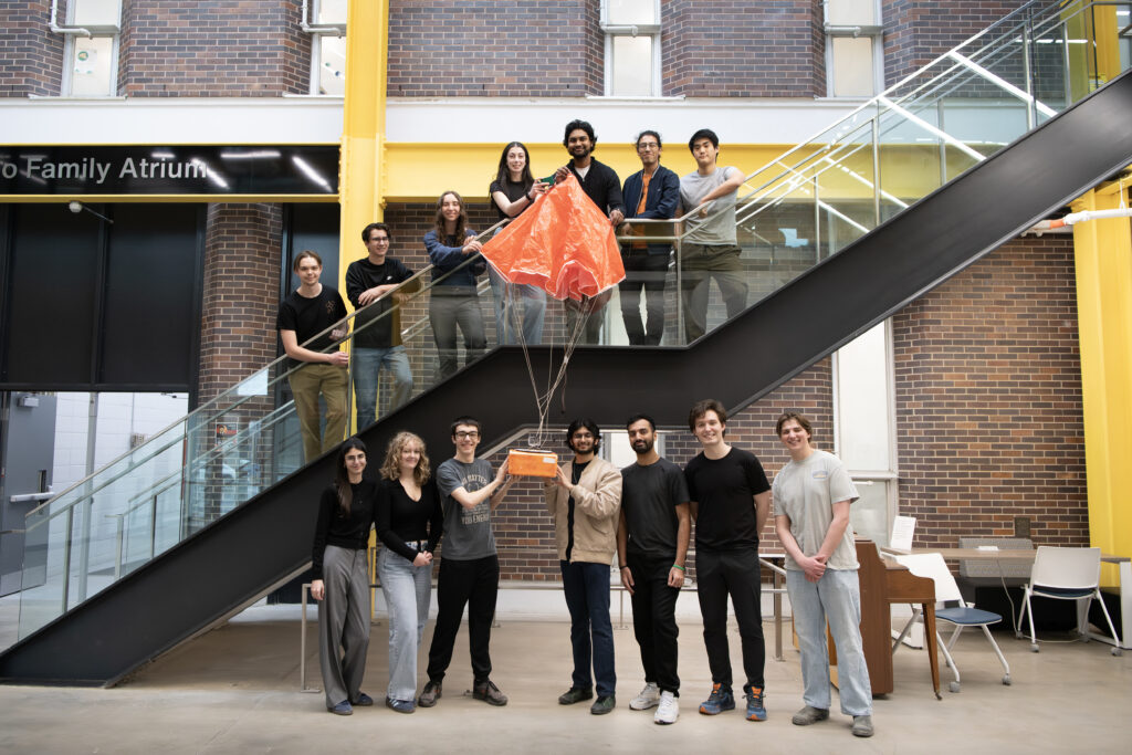 CUonOrbit team members posing in the EDC stairs with their High-Altitude Balloon 3 (HAB-3).