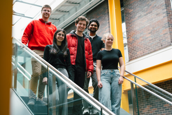Carleton students on a staircase, smiling