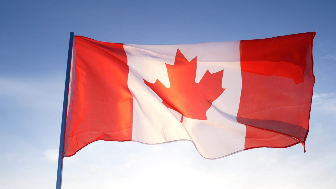 Canadian flag on clear blue sky