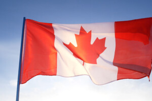 Canadian flag on clear blue sky