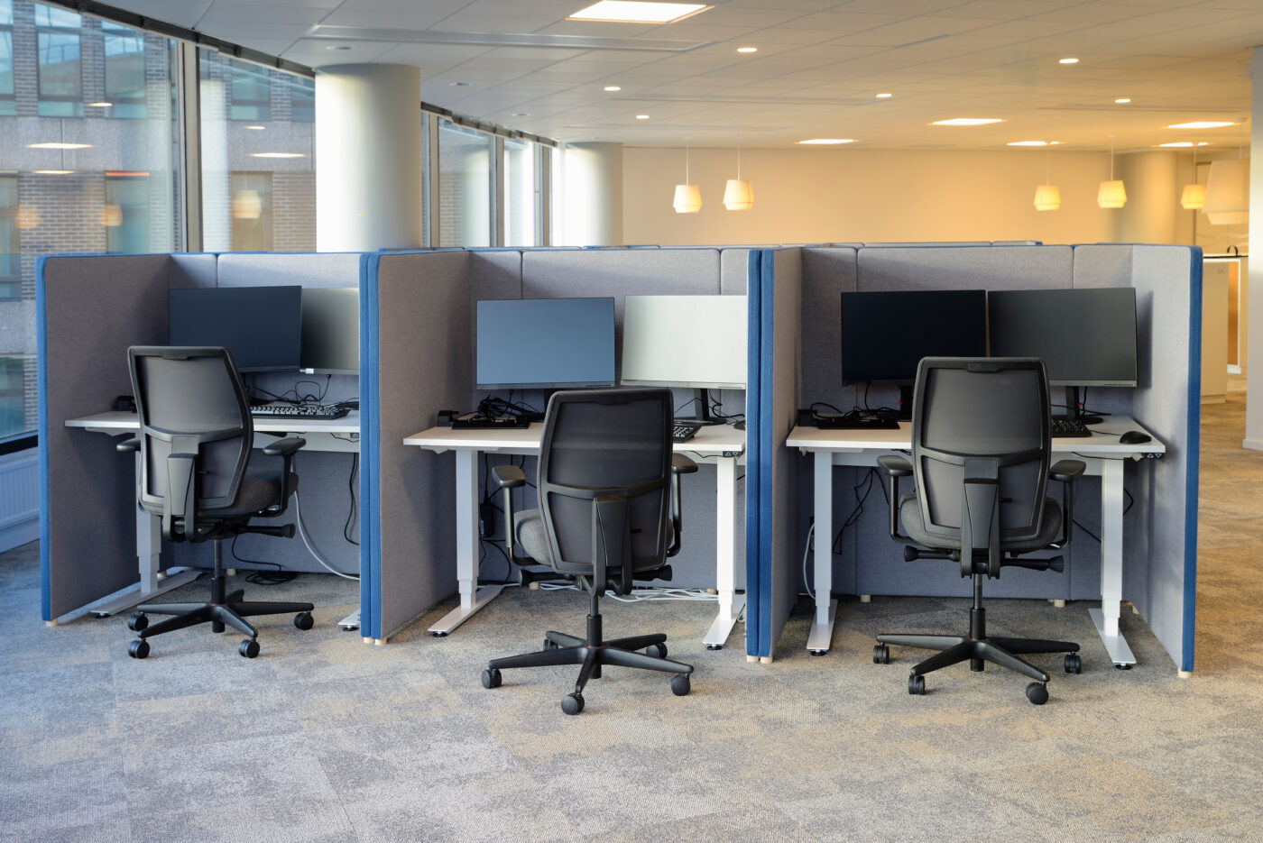 Three empty office chairs at office cubicles