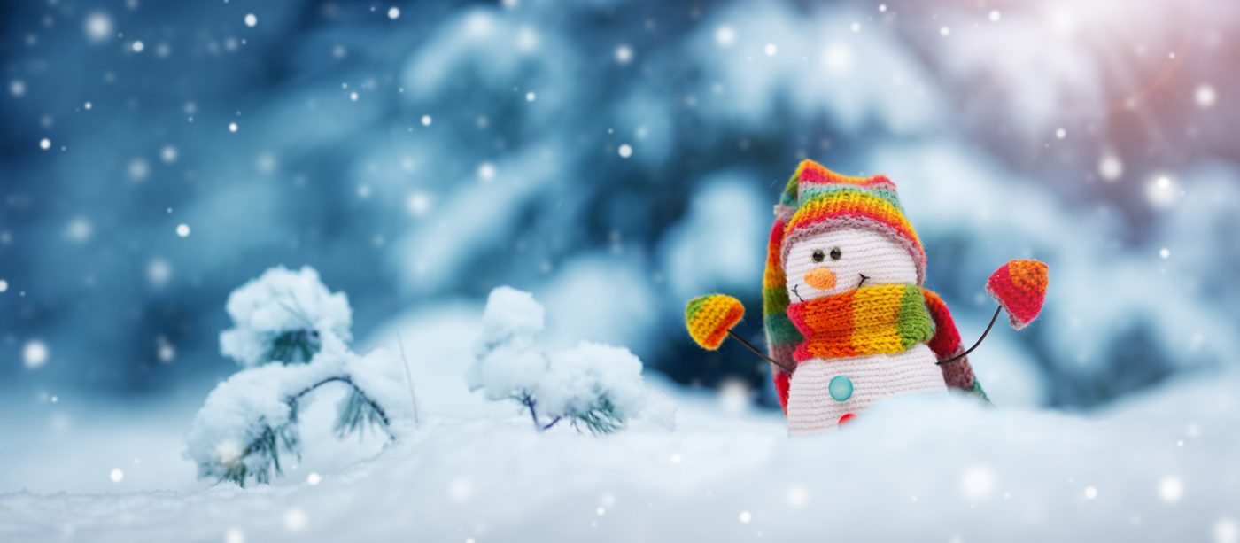 little snowman on soft snow on blue background