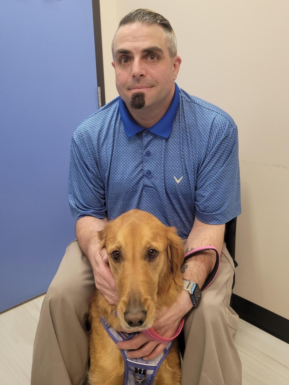 Photo of smiling student employee Anthony and his service dog, Angel.
