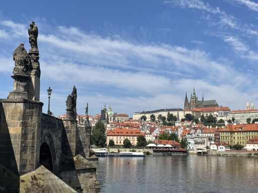 View of bridge over a river with a castle in the distance.