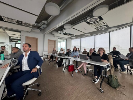 Audience members sitting and listening to presentations at a research workshop. 