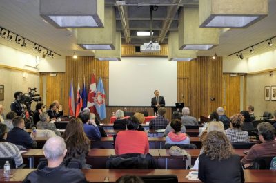 Professor speaking at a public event to a large and enthusiastic audience. 