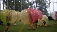 Two students playing bubble soccer.
