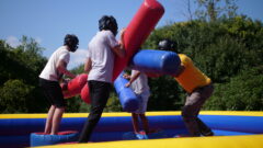 Students playing on a large joust game outdoors.