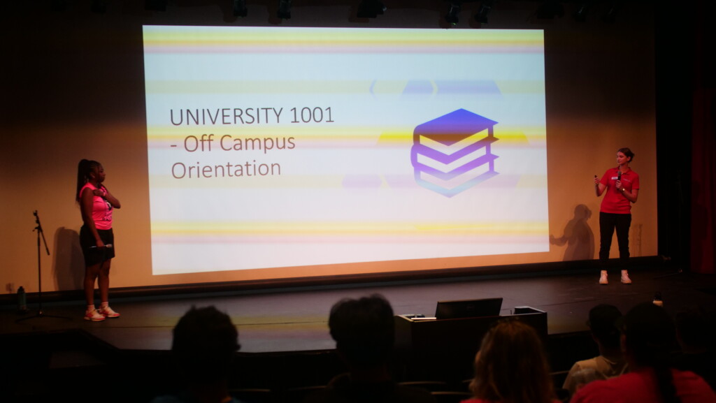 Students at front of class with a slide show.