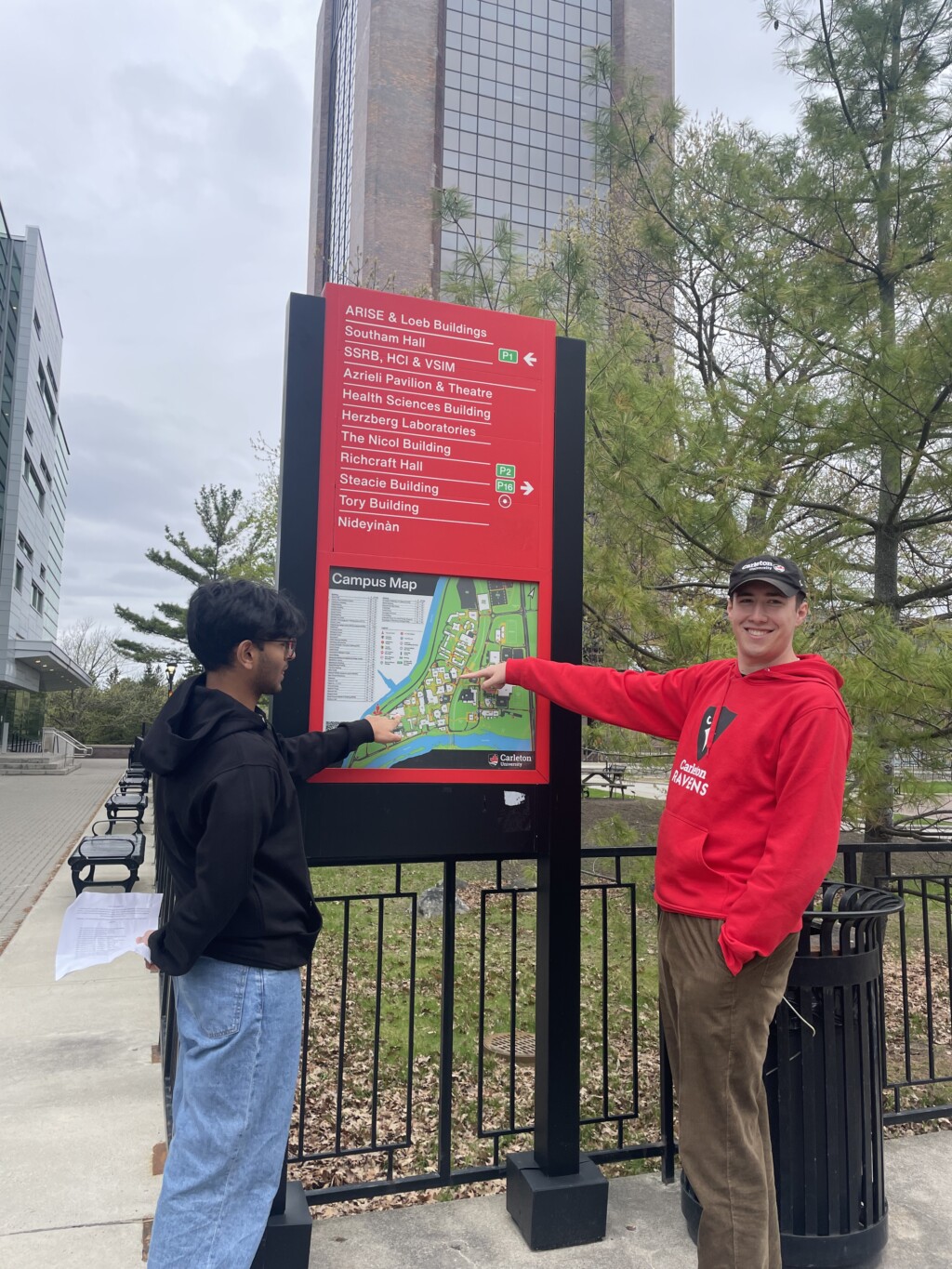 Two student pointing to a campus map.