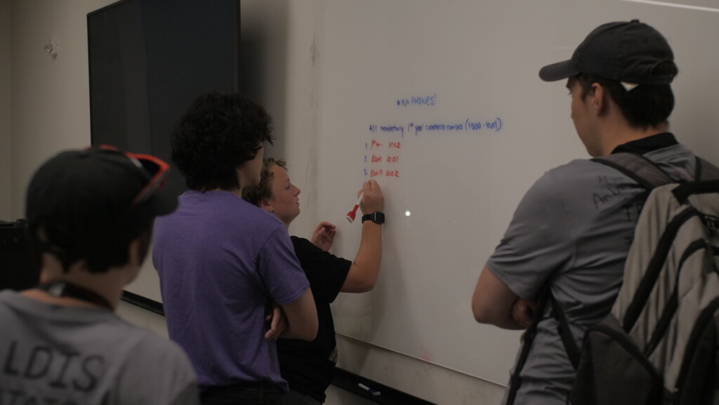 Student working on a whiteboard equation.