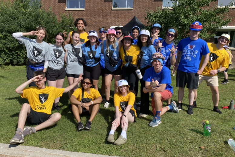Students with different teams posing for a group photo outdoors.
