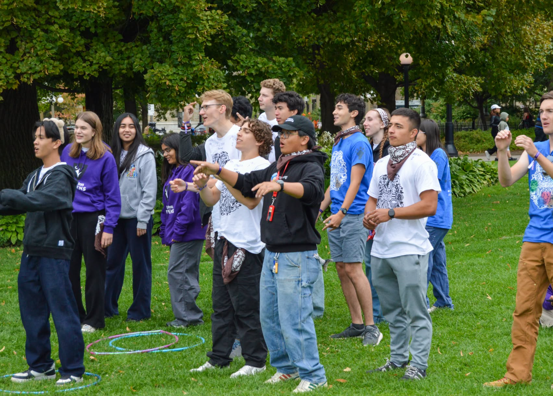 Students standing in a group while watching a performance.
