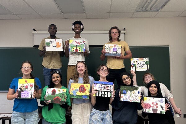 Students showing off their completed painted canvases.