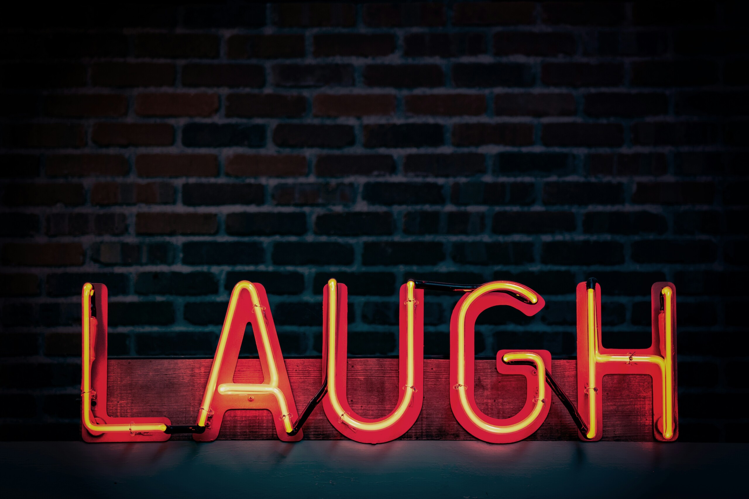 A sign that says Laugh that is lit up on stage.