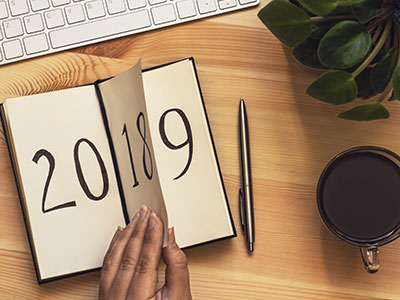 hands turning a journal page that says 2018 flipping to 2019