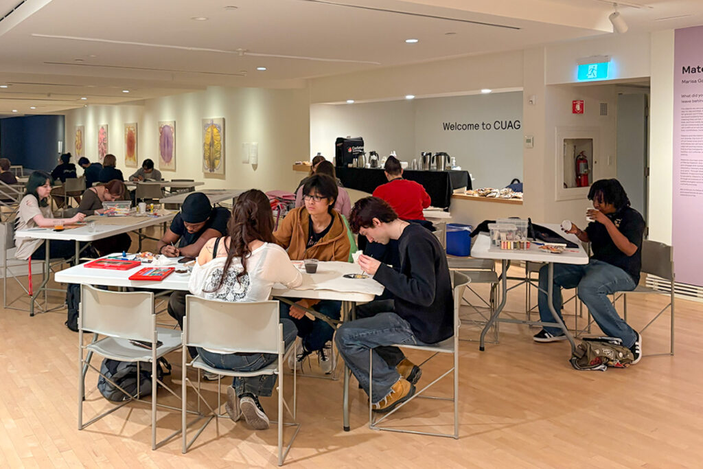 Groups of students sitting at tables making arts and crafts at the Carleton University Art Gallery.