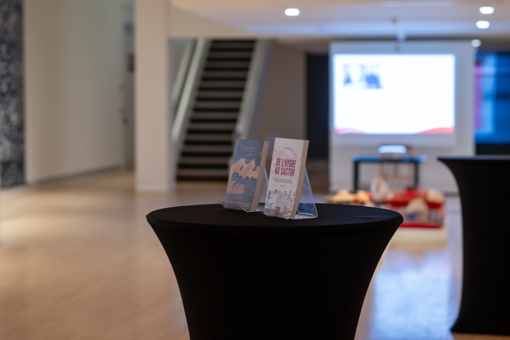Two faculty books displayed on a pedestal in the Carleton University Art Gallery.