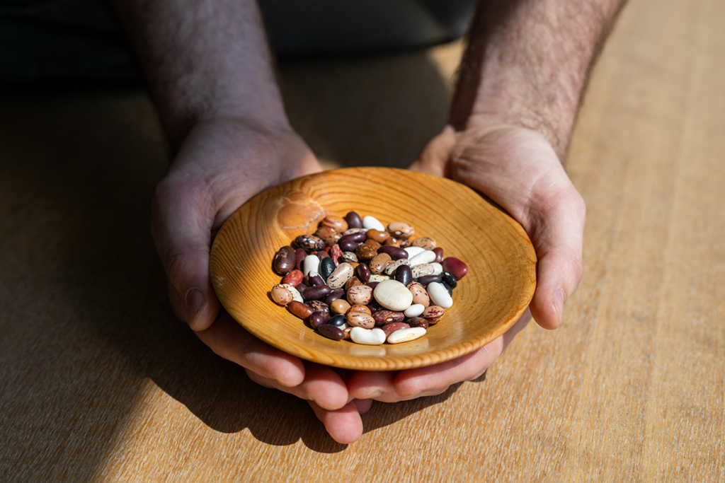 Joey Slinger holding a small bowl of mixed dried beans.