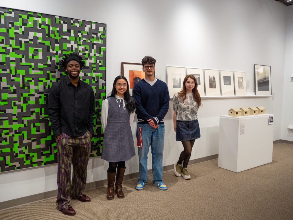 Students standing in front of their curated section of the exhibition.