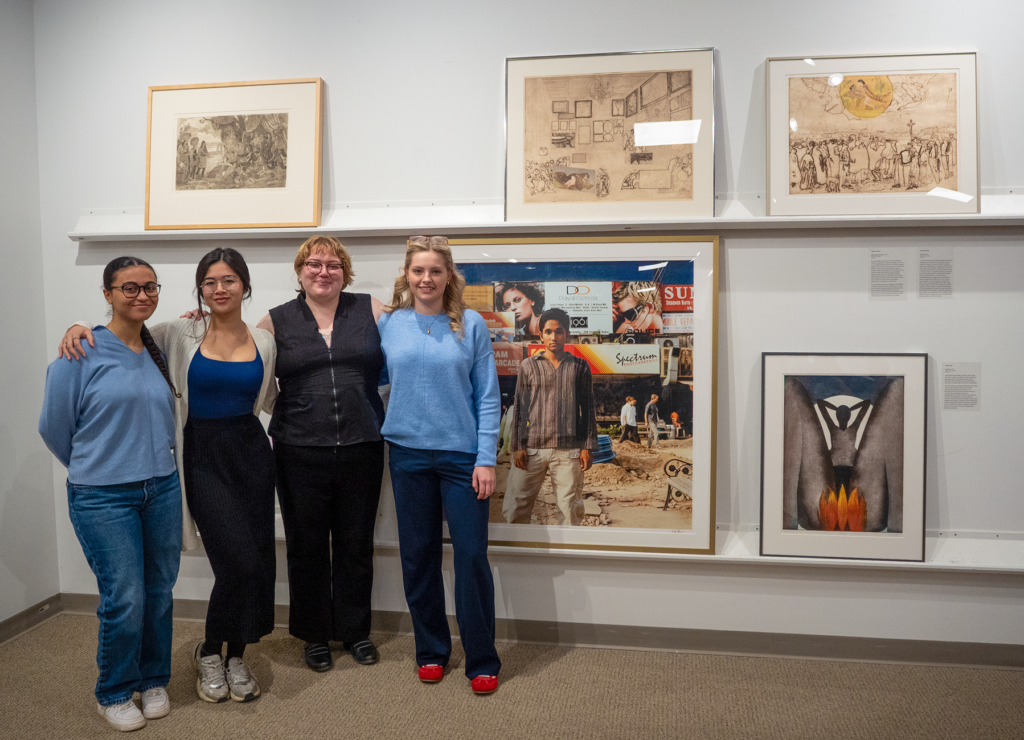 Students standing in front of their curated section of the exhibition.
