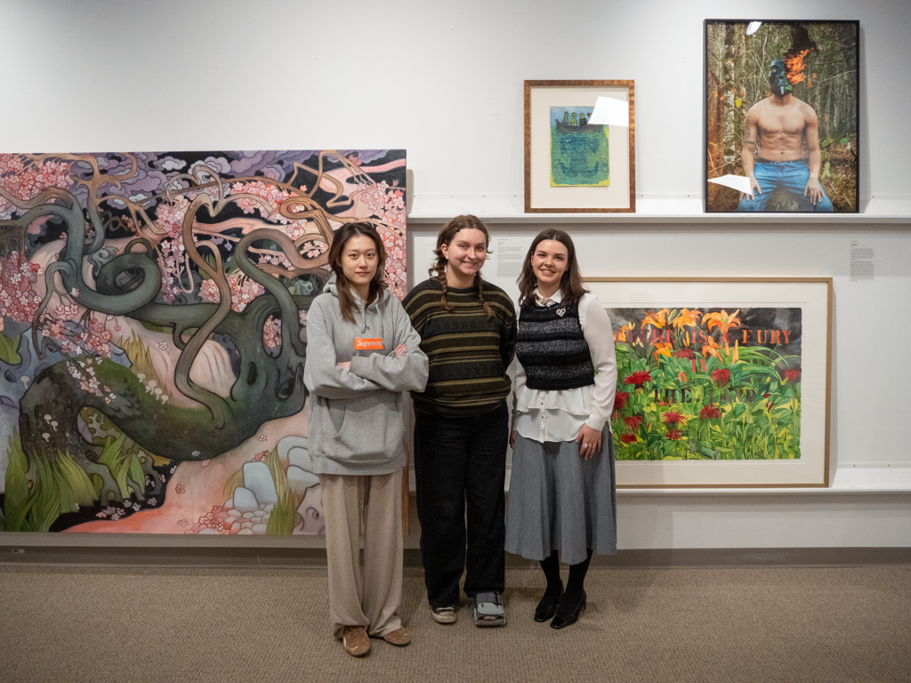 Students standing in front of their curated section of the exhibition.