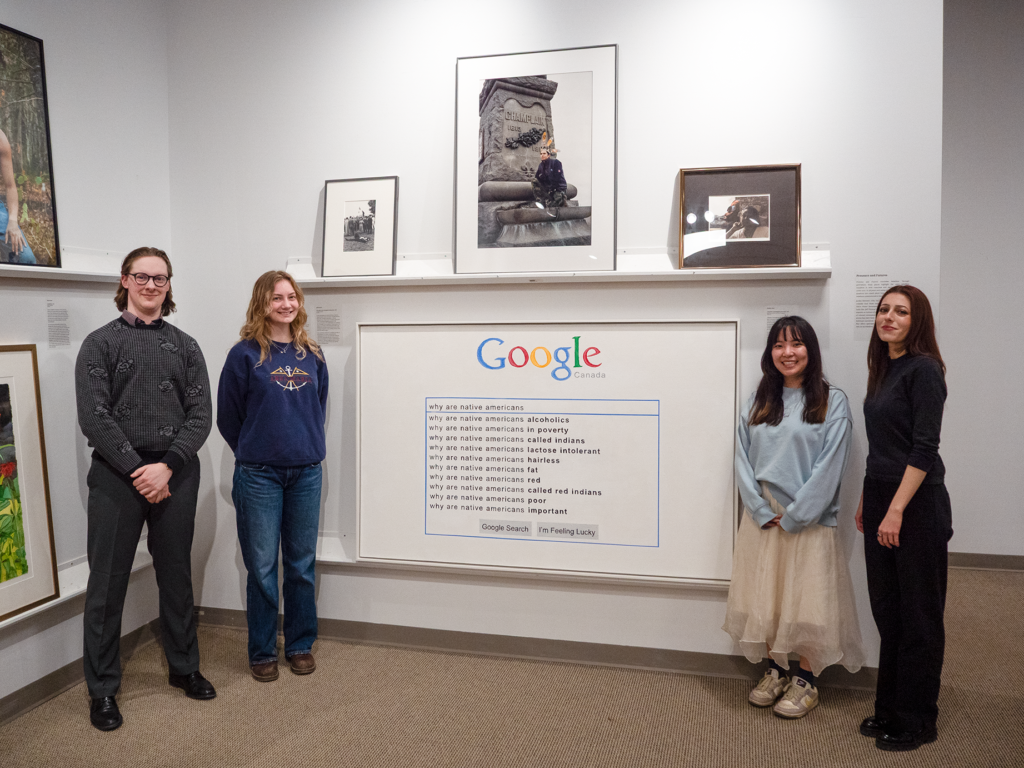 Students standing in front of their curated section of the exhibition.