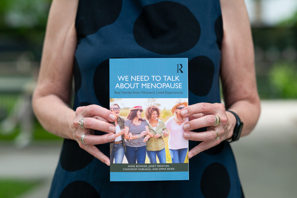 A close up shot of Anne Bowker holding a copy of the book, We Need to Talk About Menopause.
