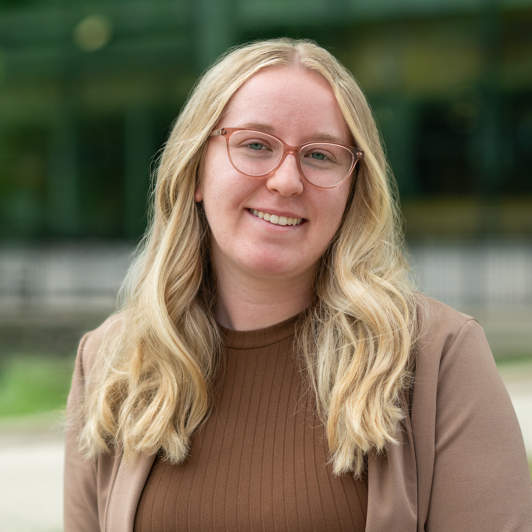 Student Ambassador with light hair, classes, and brown top