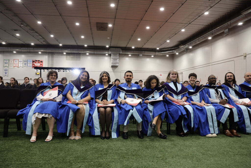 Doctoral students sitting in a row during Convocation.