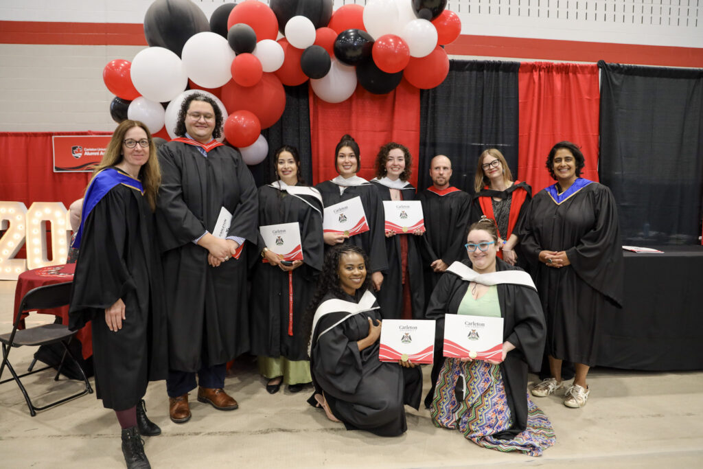 Faculty members and graduates posing for a photo at Convocation