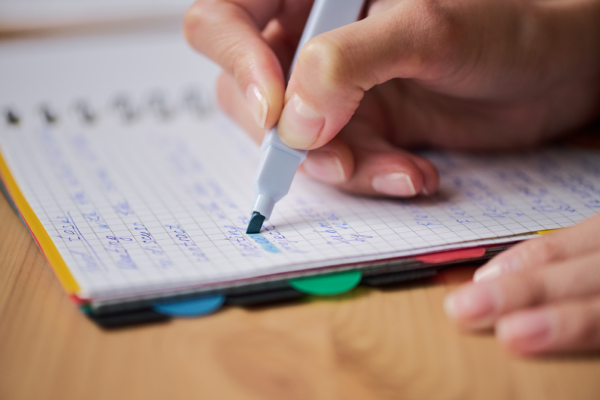 A hand highlighting something in an agenda.