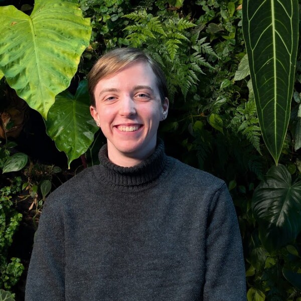 Student standing in front of green wall