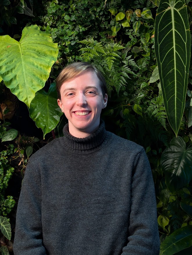 Student standing in front of green wall